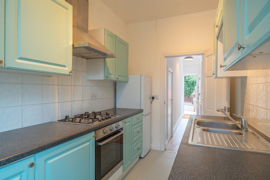 Kitchen with teal cabinets, gas hob and oven