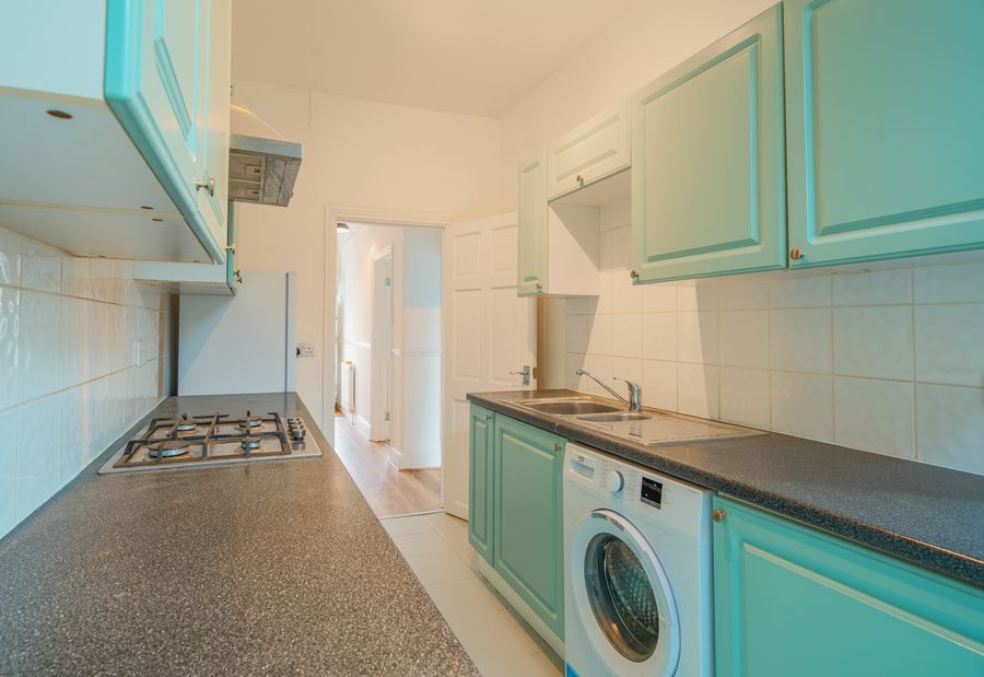 Kitchen with teal cabinets and a washing machine