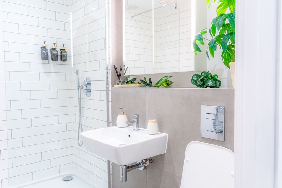 White tiled shower room with a wall-hung basin