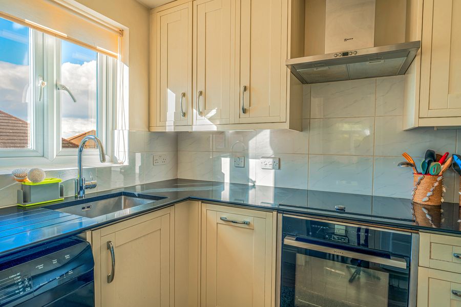 Cream shaker kitchen with dark worktops and a window