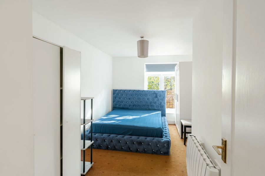 Bedroom with a blue bed, seen from the doorway