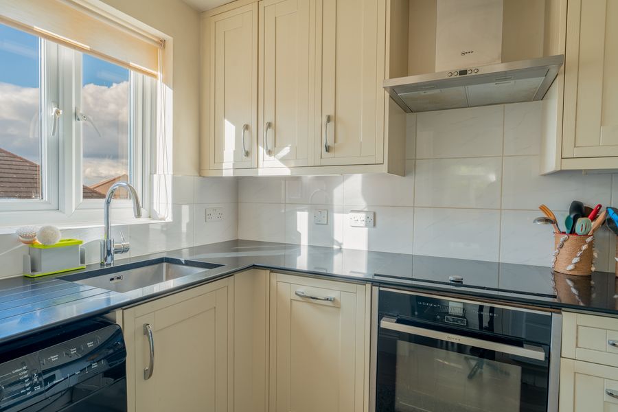 Cream shaker kitchen with dark worktops and a window