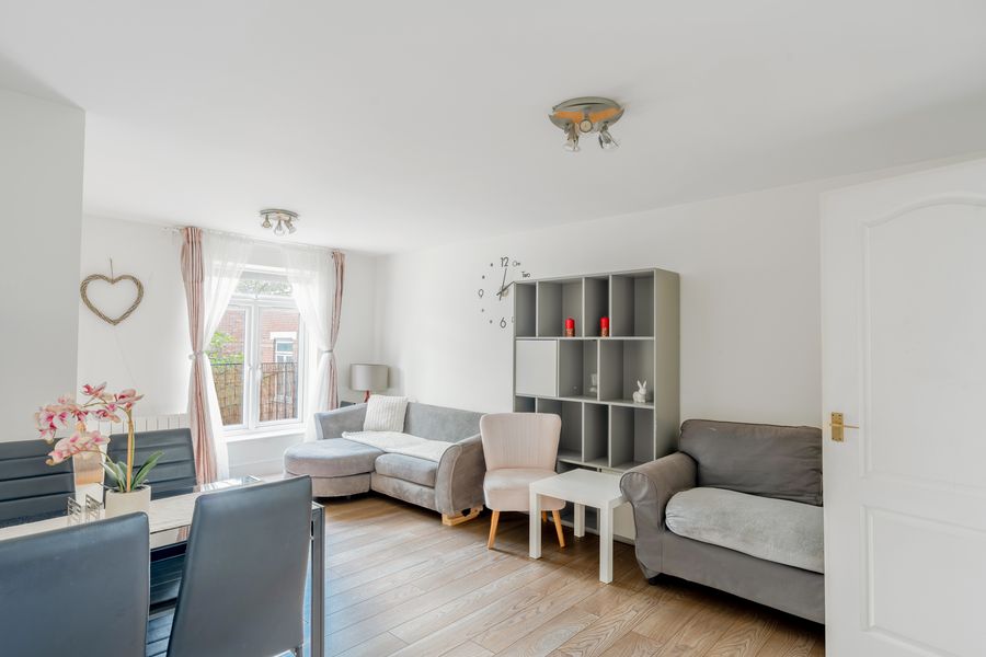 Living room with grey sofas, wooden floor and a tall window